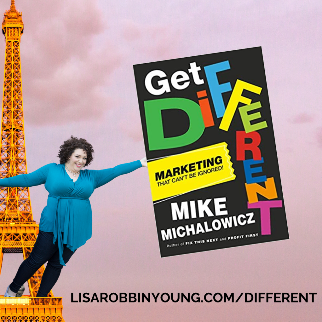 A photoshopped image of a giant-sized Lisa, hanging from the Eiffel Tower, holding an even bigger copy of Mike's book, "Get Different", with a caption featureing the URL to buy the book: Lisarobbinyoung.com/different
