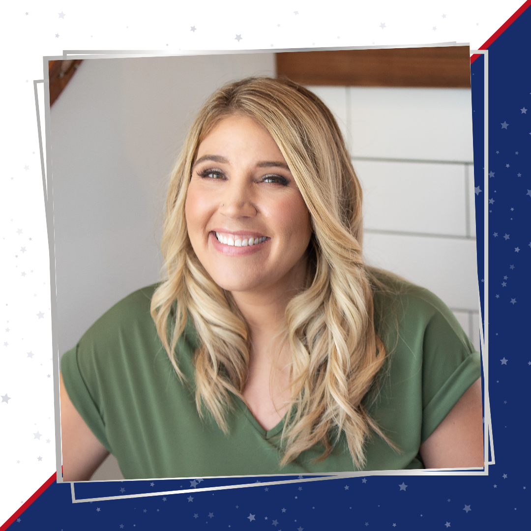 Nikky has long hair and is smiling into the camera, wearing a green blouse.