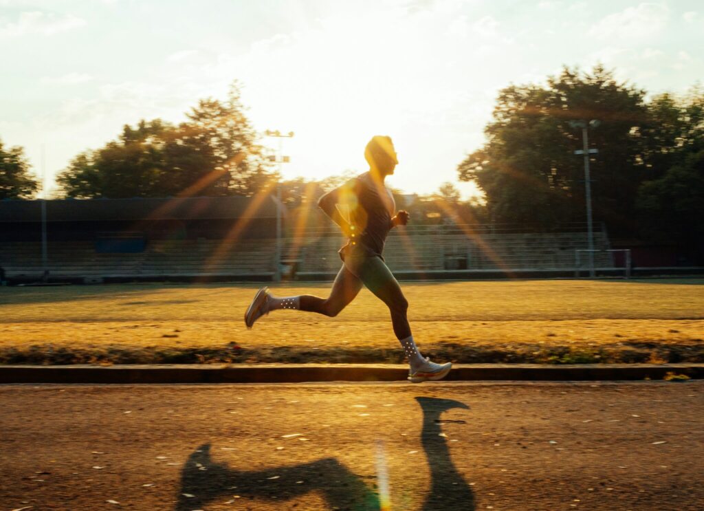 A runner on a track on a sunny day.